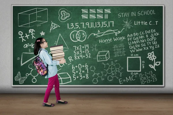 Niña llevando un montón de libros — Foto de Stock