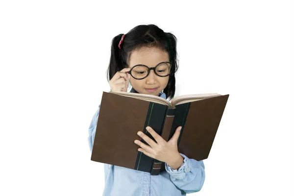 Маленькая девочка читает книгу в студии — стоковое фото
