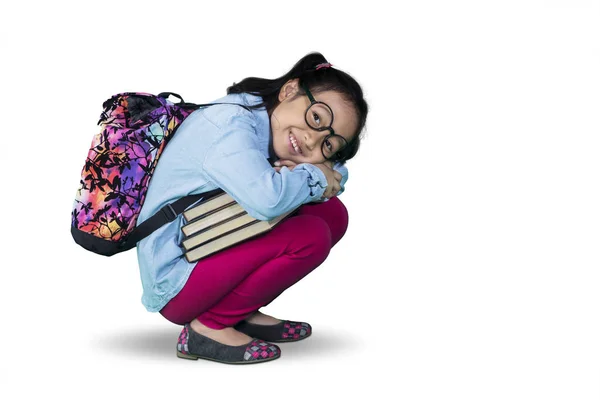 Niña sentadilla con libros en el estudio —  Fotos de Stock