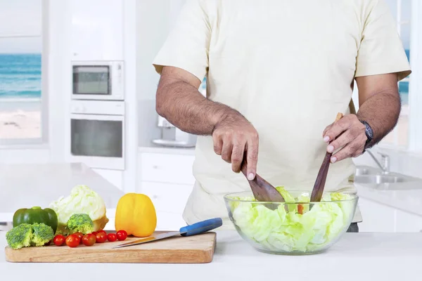 Mies ruoanlaitto vihanneksia salaatti — kuvapankkivalokuva