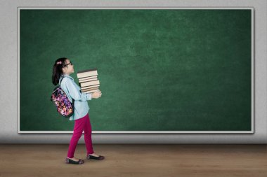 Yığın kitap sınıfta taşıyan öğrenci 