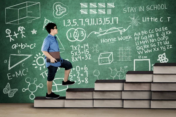 Schüler läuft mit Kritzelei auf Büchertreppe — Stockfoto