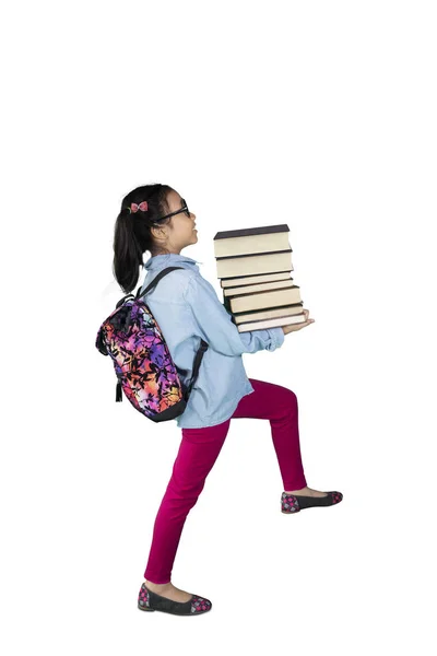 Školačka, které představují krok na schodiště s knihami — Stock fotografie