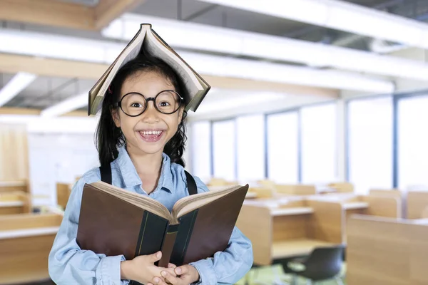 Studente sorridente con libro sopra la testa — Foto Stock