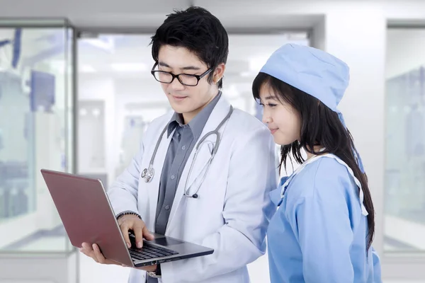 Le chirurgien et le médecin utilisent un ordinateur portable — Photo