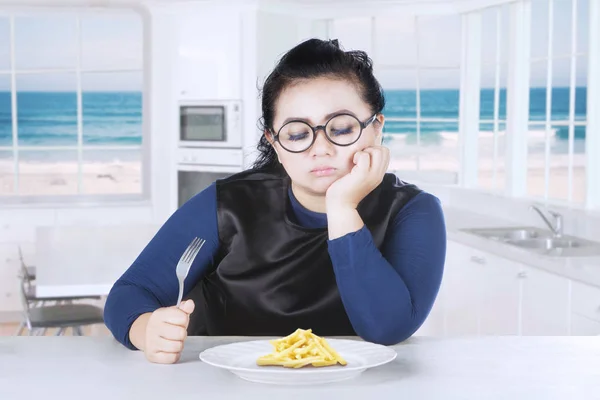 Young woman holds fork with french fries — Stock Photo, Image