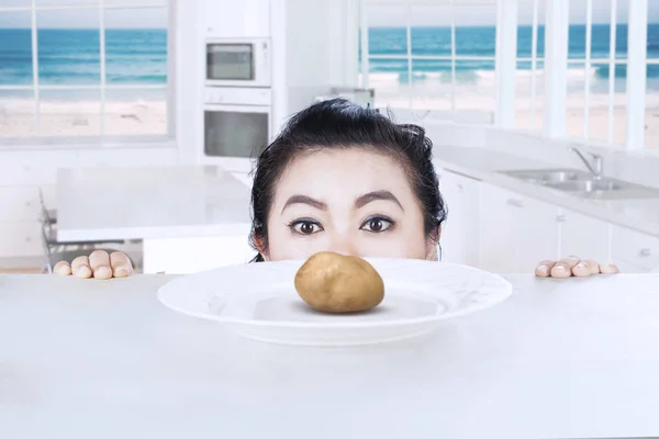 Genç kadın gözatma patates — Stok fotoğraf