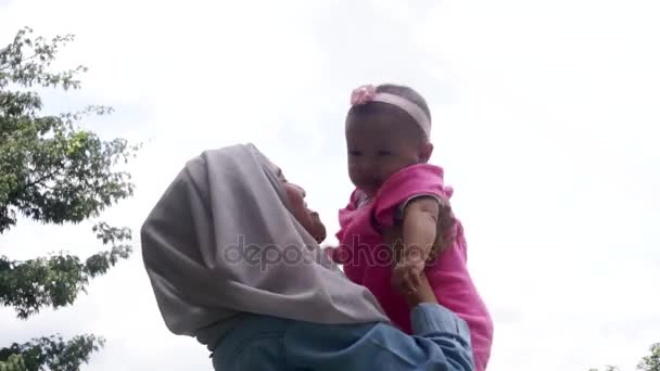 Muslim mother lifting her baby — Stock Video