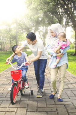 Park aile ile çocuk bisiklet ile gidiyor