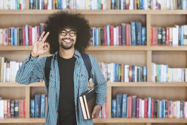 Afroamerikaner zeigt Ok-Zeichen in Bibliothek — Stockfoto