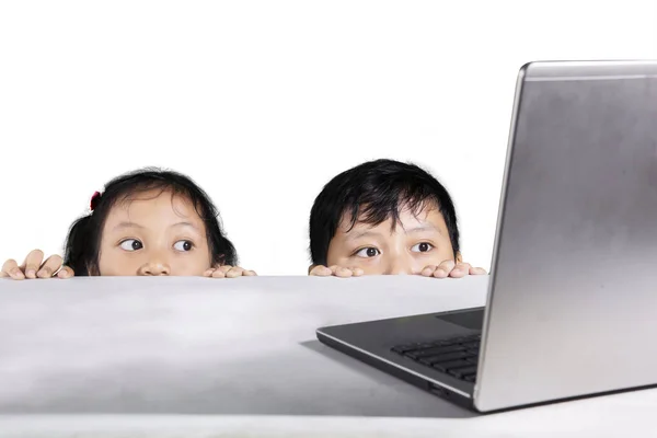 Bambini nascosti dietro un tavolo bianco — Foto Stock