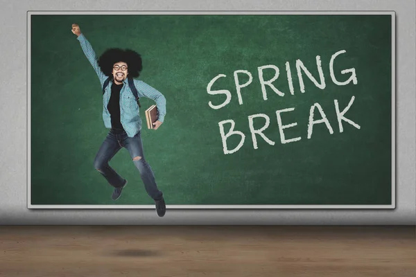 Estudiante universitario saltando con texto de vacaciones de primavera —  Fotos de Stock