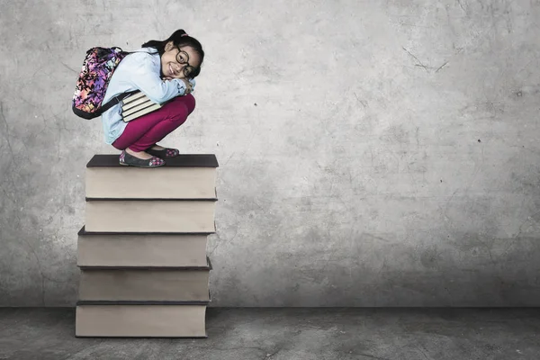 Estudante bonito agachamento em livros — Fotografia de Stock