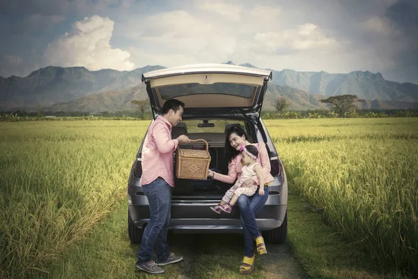 Родина тримає кошик для пікніка на рисовому полі — стокове фото