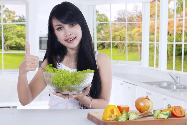 Healthy woman with thumb up holds salad — Stock Photo, Image