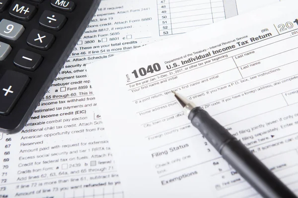 Income tax form with calculator — Stock Photo, Image