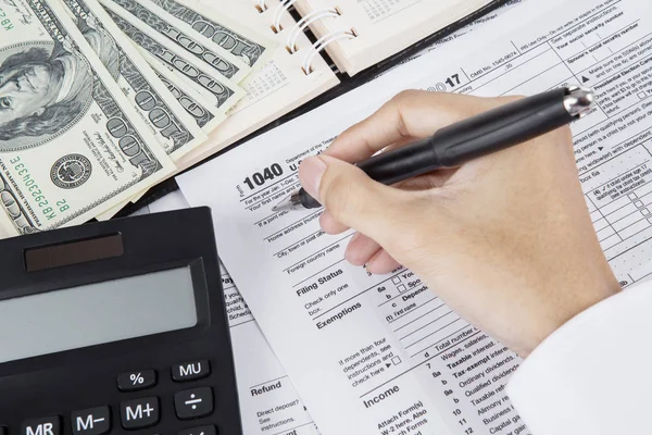 Male accountant is filing income tax form — Stock Photo, Image