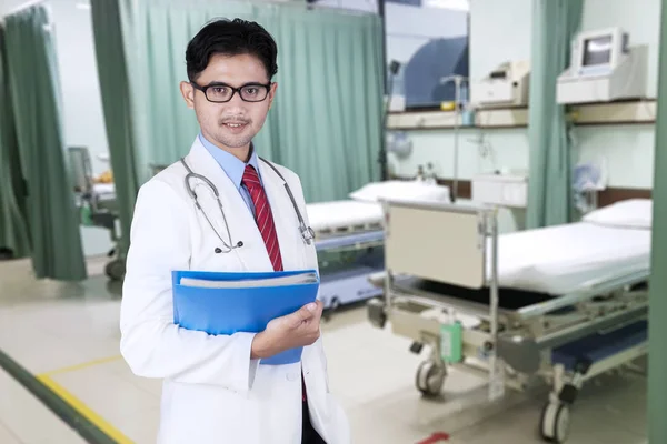 Médico masculino parece confiante com pasta — Fotografia de Stock