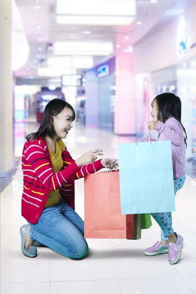 Mãe e filha olhando em sacos de compras — Fotografia de Stock
