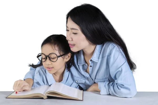 Νεαρή γυναίκα διδάσκει το παιδί να διαβάσει — Φωτογραφία Αρχείου
