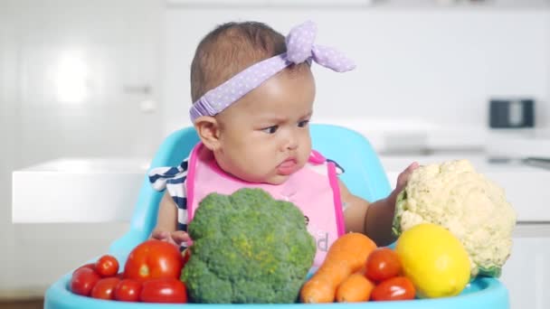Милый ребенок играет в овощи на кухне — стоковое видео