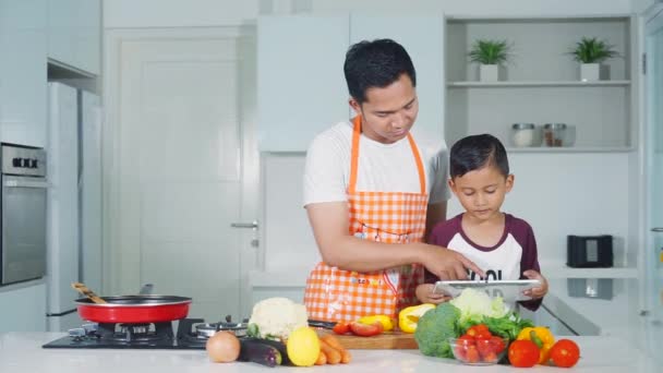 Niño y padre cocinando en la cocina — Vídeo de stock
