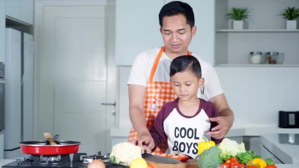 Человек и его сын хлопают в ладоши на кухне — стоковое видео