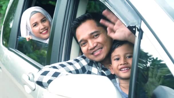 Muslim family waving hands inside car — Stock Video