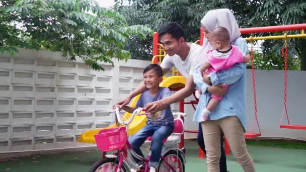 Föräldrar lär sin son åka cykel — Stockvideo