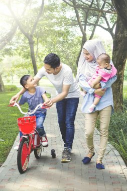 Bisiklet sürmeyi oğulları öğretim aile