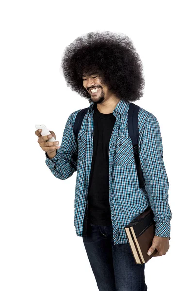 Afro student hledá smartphone s knihou — Stock fotografie