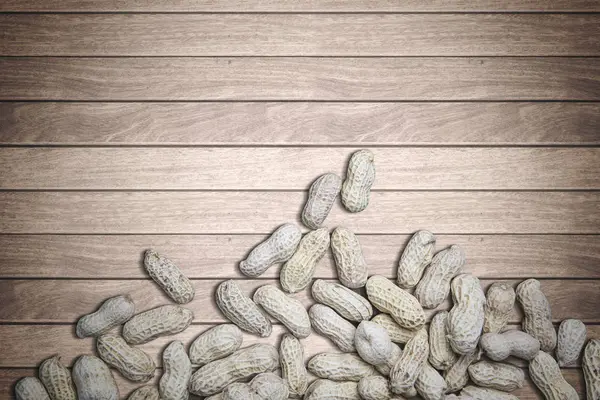 Amendoins crocantes sobre fundo de madeira — Fotografia de Stock