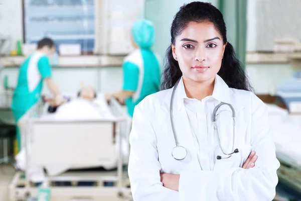 Vrouwelijke arts kijkt vol vertrouwen op patiënt kamer — Stockfoto