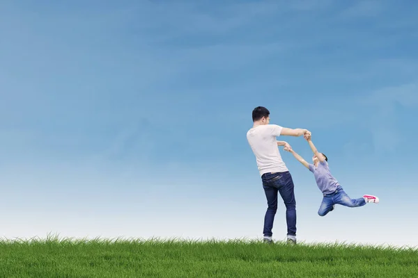 Jeune père joue avec son fils dans la prairie — Photo