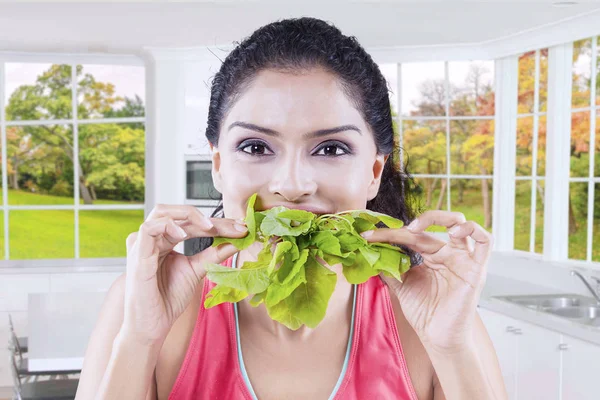 Mujer joven mordiendo espinacas con fondo de otoño — Foto de Stock