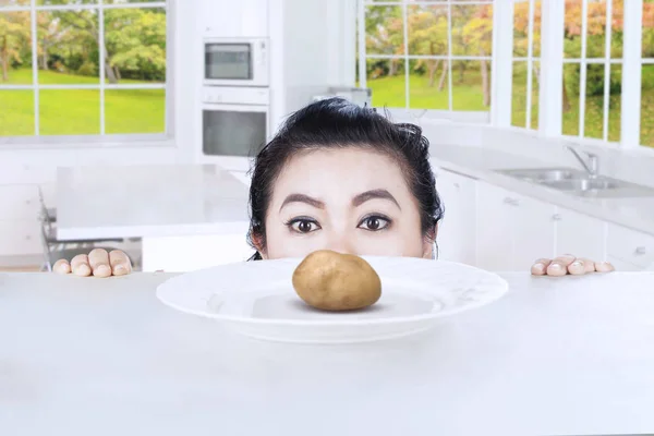 Young woman peeks boiled potato — Stock Photo, Image