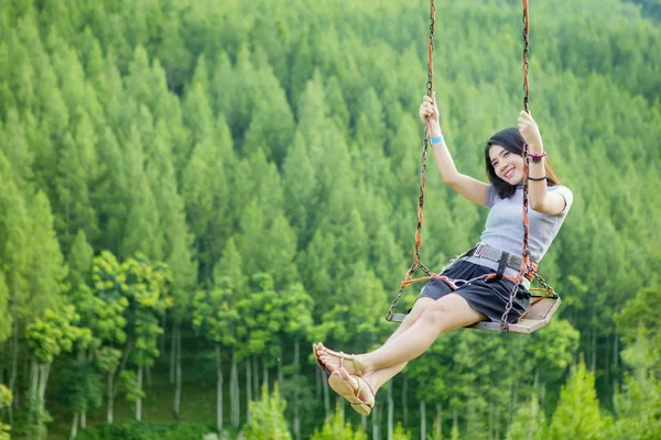 Asian woman playing on swing — Stock Photo, Image