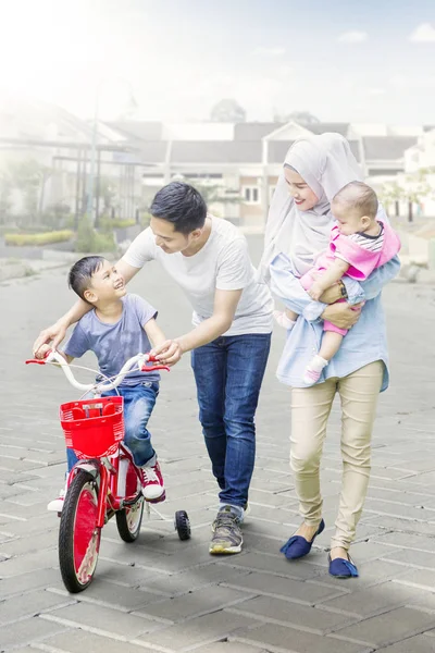 Ragazzo imparare ad andare in bicicletta con i suoi genitori — Foto Stock