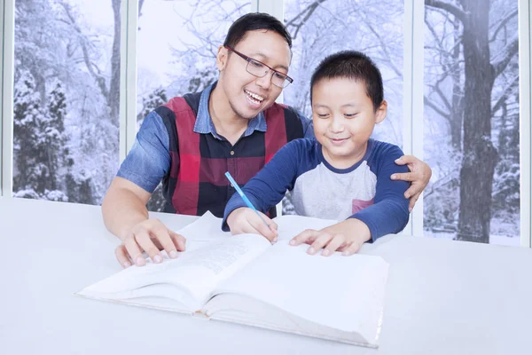 Mignon garçon étudiant avec père à la maison — Photo