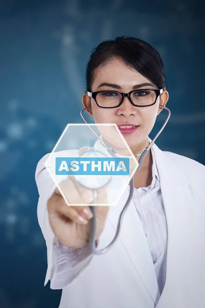 Женщина-врач со словом астмы и стетоскопом — стоковое фото