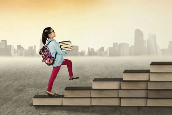 Estudiante femenina pisando la escalera de libros —  Fotos de Stock