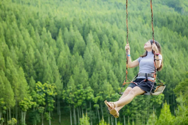 Joyful woman playing on swing — Stock Photo, Image