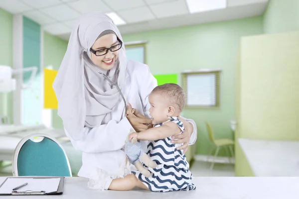 Pediatra muçulmano examinando bebê pequeno — Fotografia de Stock