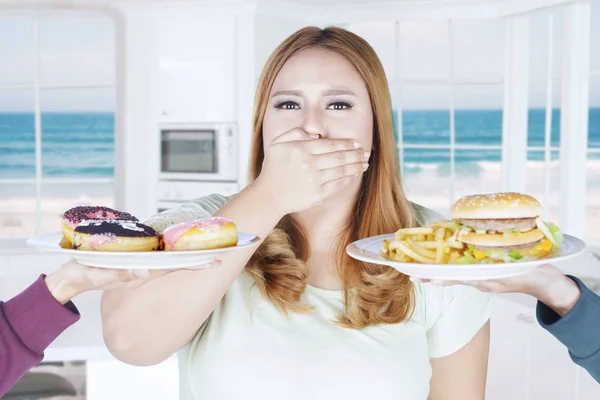 Толстая женщина закрыла рот для нездоровой пищи — стоковое фото