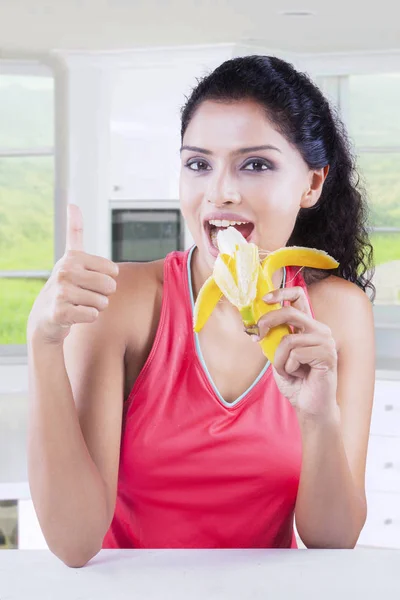 Junge Frau isst eine frische Banane — Stockfoto
