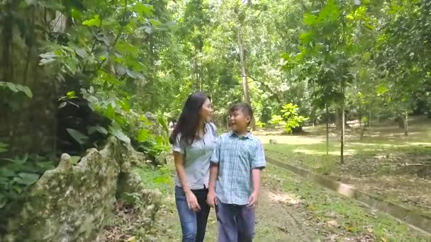 Garçon et sa mère marchant dans la forêt — Video