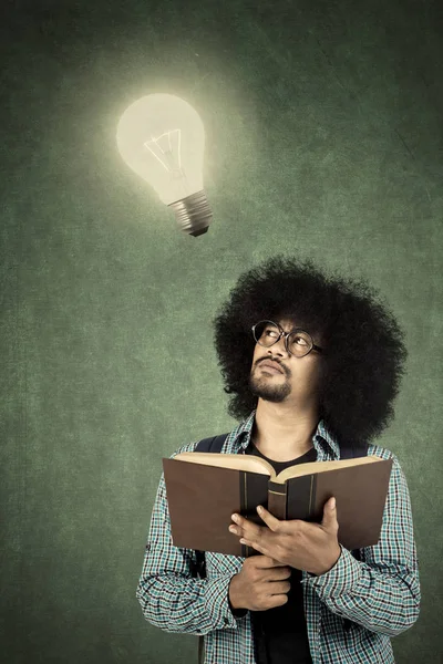 Afro mens denken-idee met gloeilamp — Stockfoto