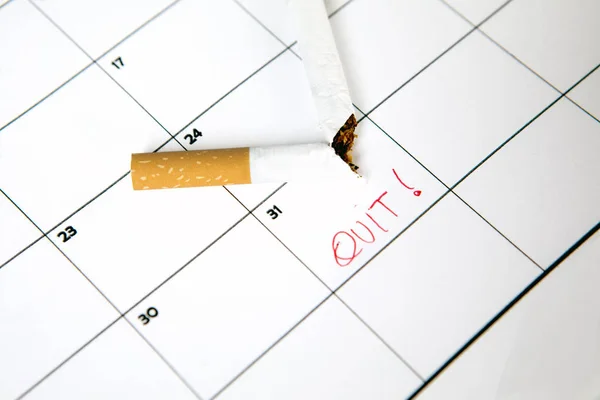 Cigarro partido no calendário — Fotografia de Stock