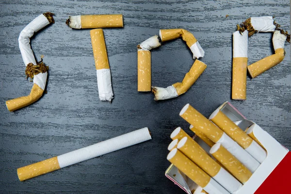 Niedopałki papierosów i Stop smoking słowo — Zdjęcie stockowe