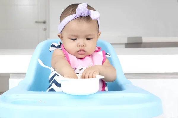 Bonito bebê menina comer comida na cozinha — Fotografia de Stock